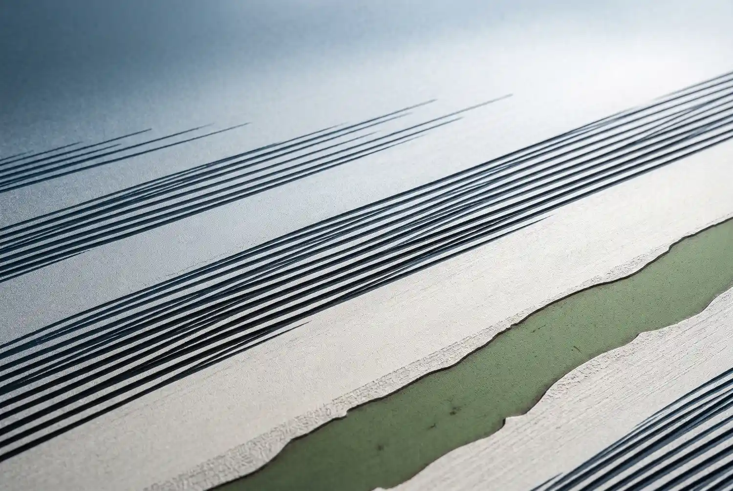 A frost-etched graphic study of parallel mow-stripe courses cut across turf, in cool steel-blue and pale frost tones with a sage-moss diagonal band crossing the lower-right of the frame.